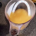 measuring cup full of soup stock