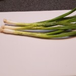 whole green onions on a cutting board