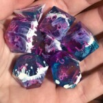 purple and teal dice with white alcohol ink in the middle
