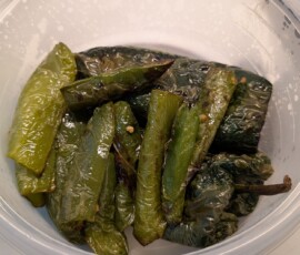 peppers fresh out of roasting in the airfryer and into a tupperware container to steam